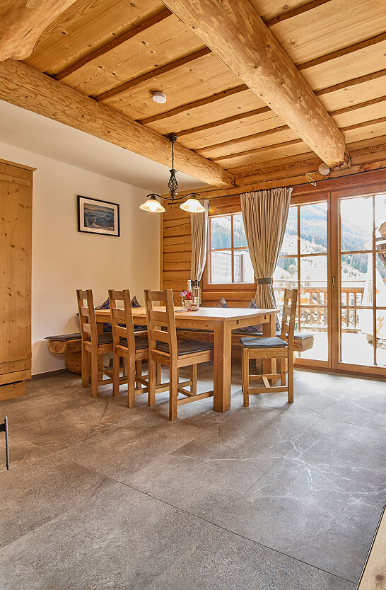 Holzvertäfeltes Esszimmer mit Tisch, Stühlen, Bergblick.