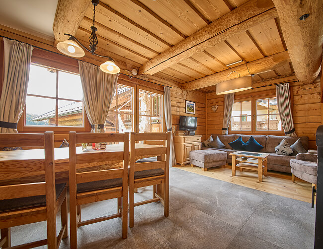 Helle Holzstube mit Esstisch und Wohnbereich.