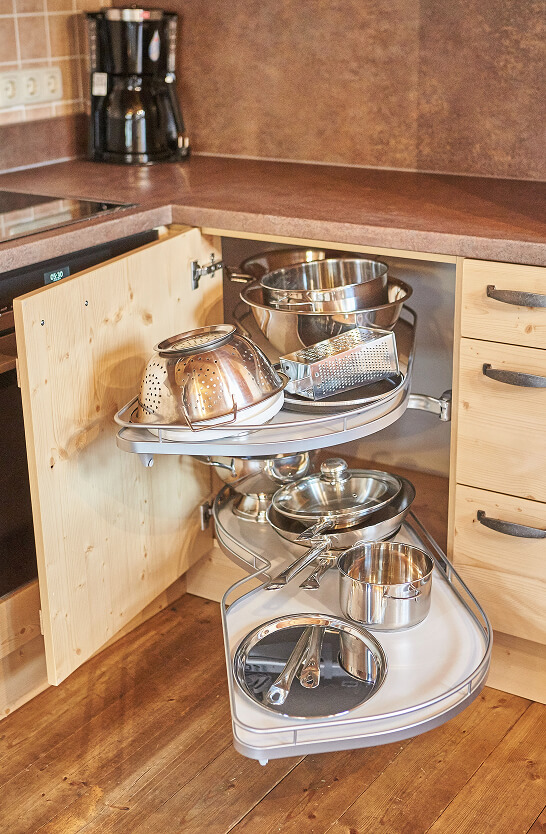 Eckschrank mit ausziehbarem Edelstahl-Kochgeschirr.