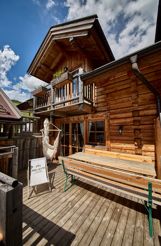 Heller Holzbalkon mit Sitzmöbeln und Bergpanorama
