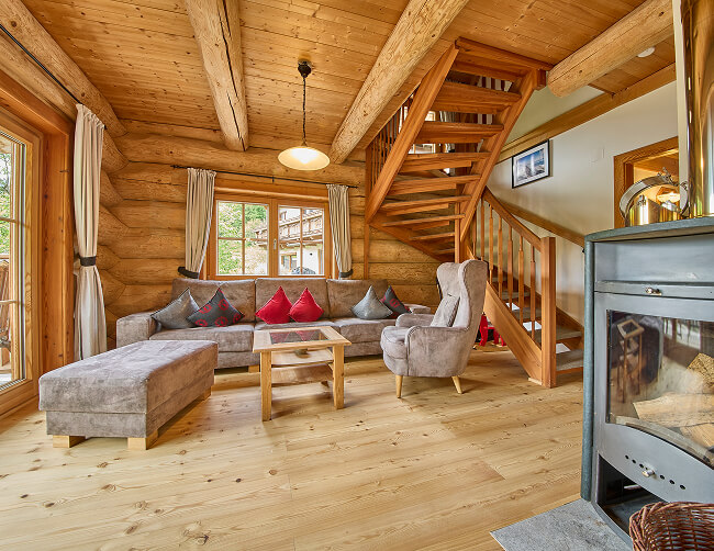 Helles Holz-Wohnzimmer mit Sofa, Treppe und Kamin.