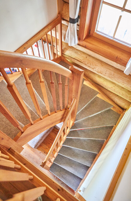 Holztreppe mit Teppichläufer, Blick von oben.