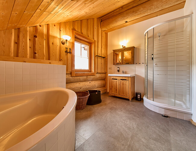 Badezimmer mit Badewanne, Dusche, Holzvertäfelung.