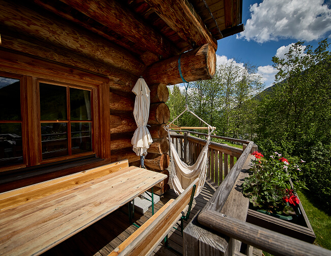 Heller Holzbalkon mit Sitzmöbeln und Hängesessel