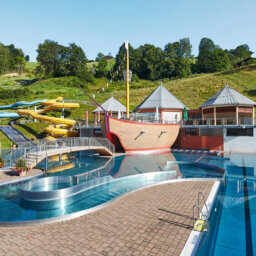 Freibad mit Holzschiff, Wasserrutschen, Pools.