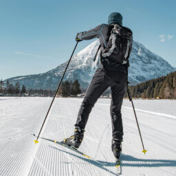 Person beim Langlauf auf Loipe vor Schneeberg.