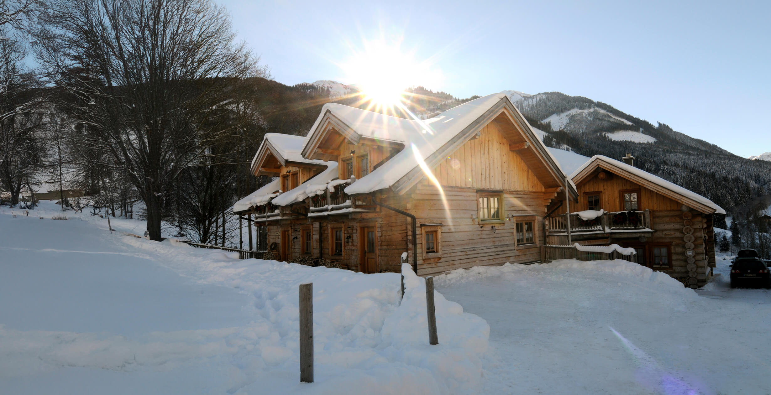 Helle Winterlandschaft mit verschneiten Holzhäusern.
